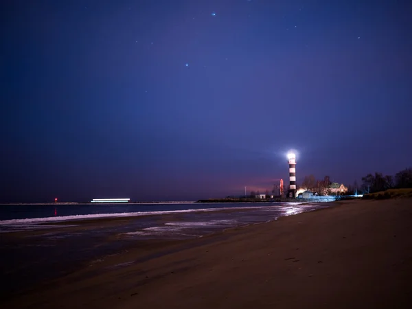 Черно-белый маяк ночью на пляже Балтийского моря — стоковое фото