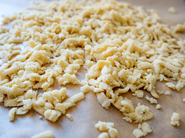 Prepared grated row dough on wooden table — 스톡 사진