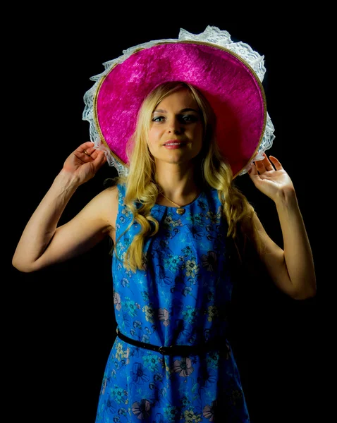 Mulher bonita em vestido azul segurando chapéu rosa — Fotografia de Stock