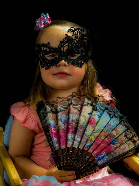 Ragazza con ventilatore e maschera in abito — Foto Stock