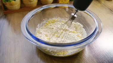 Closeup un ile zaten kadar dövülmüş yumurta ve şeker bir el mikseri kullanarak karıştırma