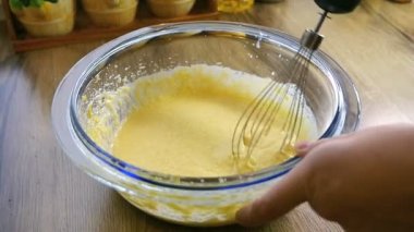 Closeup un ile zaten kadar dövülmüş yumurta ve şeker bir el mikseri kullanarak karıştırma