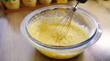 Un ile zaten kadar dövülmüş yumurta ve şeker bir el mikseri kullanarak karıştırma Closeup yavaş hareket
