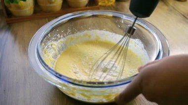 Un ile zaten kadar dövülmüş yumurta ve şeker bir el mikseri kullanarak karıştırma Closeup yavaş hareket