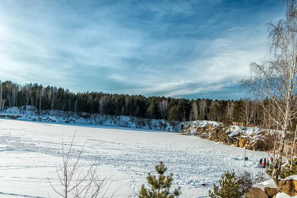 Une carrière gelée avec des arbres poussant dessus par une journée ensoleillée. — Photo