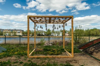 Bulutlu bir gökyüzüne karşı yerde duran küp şeklinde metal bir yapı..