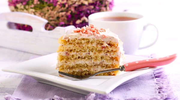 Slice of layered cake with topping — Stock Photo, Image