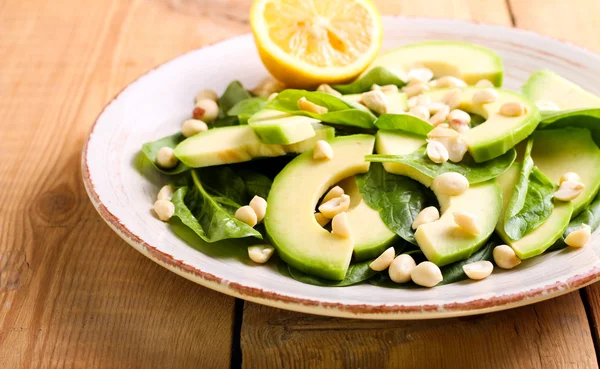 Salade van spinazie, avocado en pinda's op plaat — Stockfoto