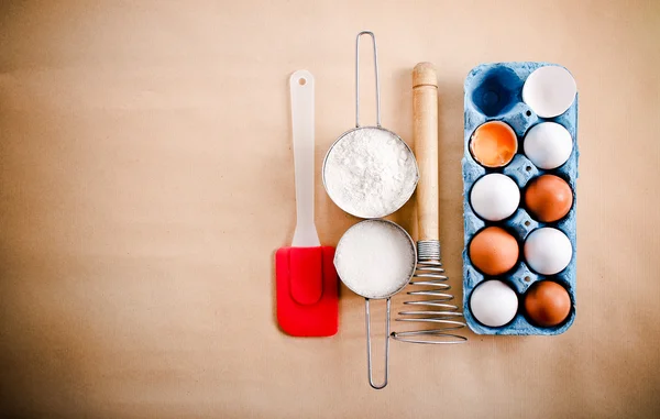 White and brown eggs, whisker and cups with flour and sugar — Stock Photo, Image