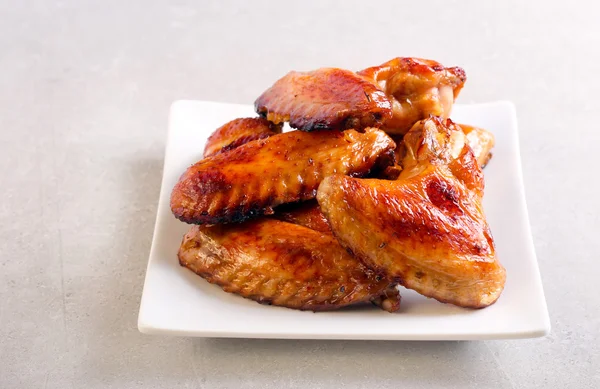 Asas de frango assadas no prato — Fotografia de Stock