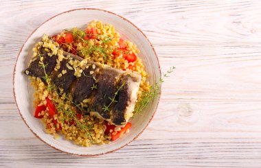 Tabağında bulgur olan yayın balığı.