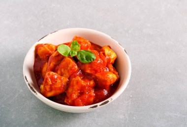 Tavuk fileto, domates sosunu kasede ısırır.