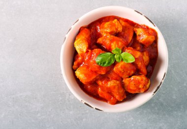 Tavuk fileto, domates sosunu kasede ısırır.