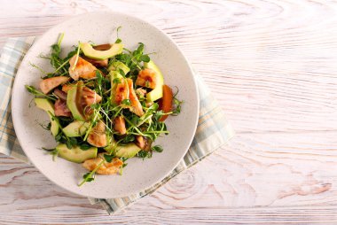 Tavuk, avokado, domates ve tabakta salata.