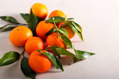 Masada yaprakları olan mandalina meyveleri.