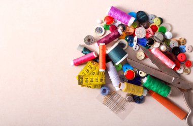 Düğmeler, iplik ve makas makaraları ile arkaplan dikiliName