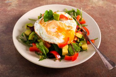 Avokado, salata karışımı ve kızarmış yumurtalı kırmızı biber salatası.