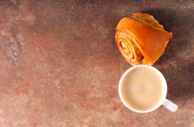 Tarçınlı çörek ve bir fincan kahve.