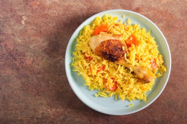 Pirinç ve havuçlu baharatlı tavuk budu.