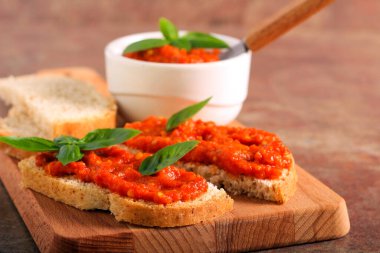 Ekmek dilimlerinin üzerine yayılmış kızarmış sebzeler.