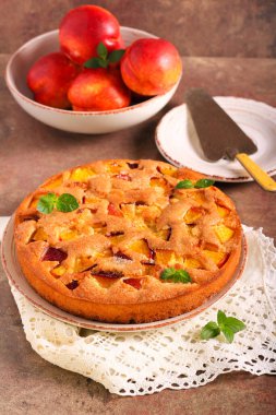 Taze ve yumuşak nektarinli kek, taş masanın üstünde.