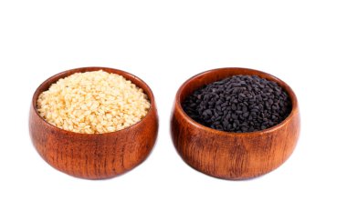 Siyah ve beyaz susam tohumları beyaz arka plan üzerinde ahşap kaseler