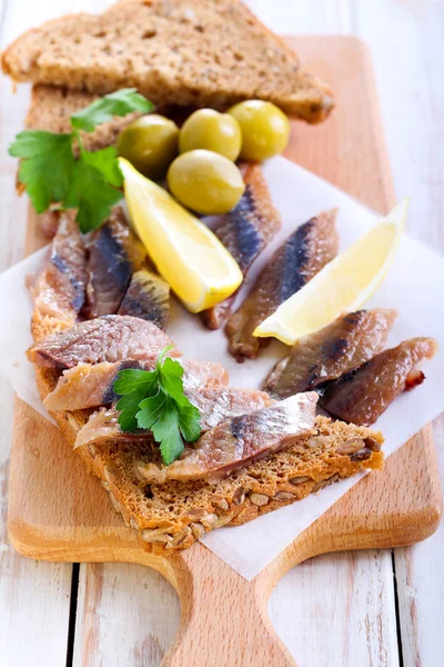 Geräucherte Fischstücke auf braunem Kernbrot — Stockfoto