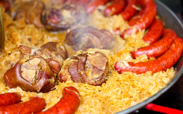 Свинина, сосиски та тушкована капуста — стокове фото