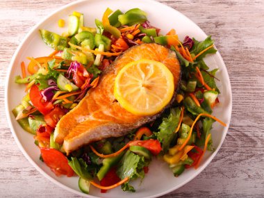 Lemon salmon with salad on plate