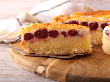 Tahtada dilimlenmiş vişneli ve peynirli kek.