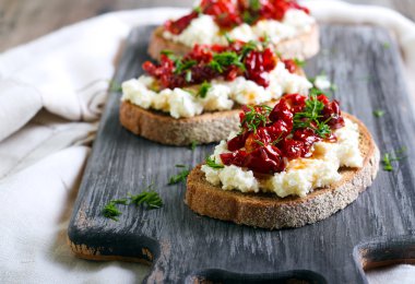 Ekmek dilimleri ve ricotta peyniri, güneş ile kurutulmuş domates