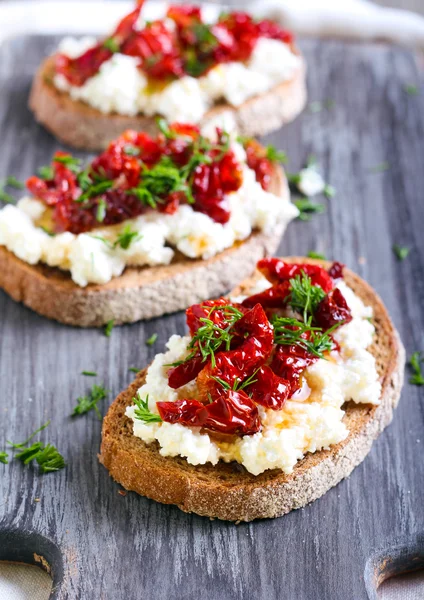 Ekmek dilimleri ve ricotta peyniri, güneş ile kurutulmuş domates — Stok fotoğraf