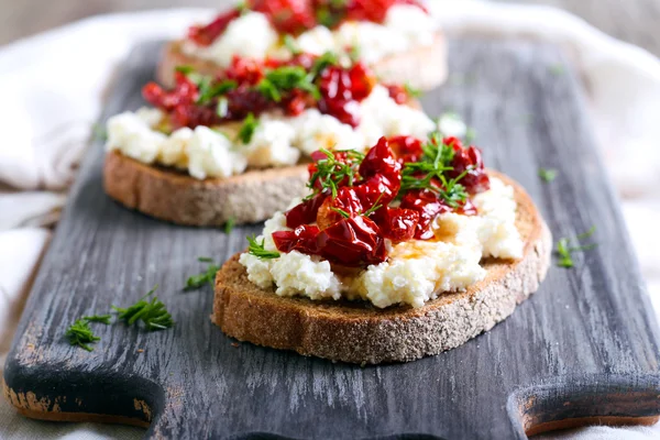 Ekmek dilimleri ve ricotta peyniri, güneş ile kurutulmuş domates — Stok fotoğraf