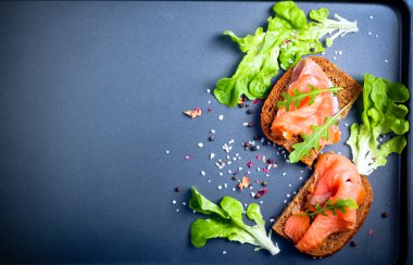 Siyah arka plan üzerinde kahverengi ekmek ile Somon