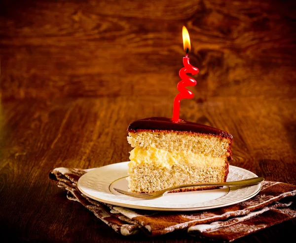 Kuchen mit Kerzen auf dunklem Holzgrund — Stockfoto