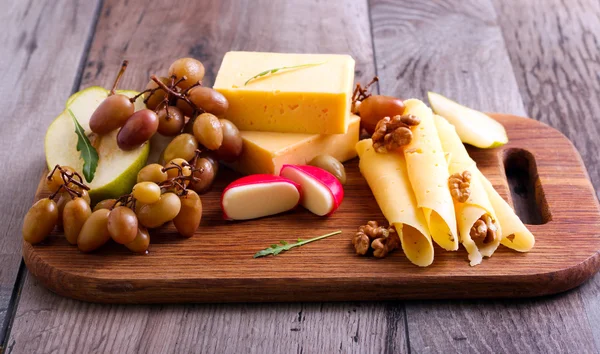 Cheese board with marinated grapes — Stock Photo, Image