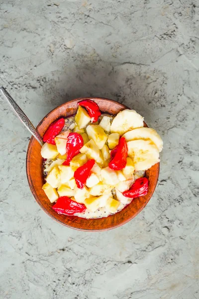 Aveia com banana e morango em um prato de barro — Fotografia de Stock