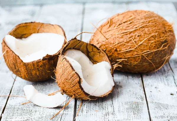 Fresh coconuts in the shell on a blue wooden background — Stock Photo, Image