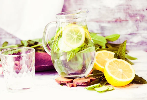 Water met citroen, munt en komkommer in glas, roze tint — Stockfoto