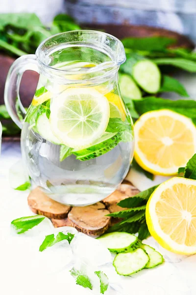 Water with lemon, mint and cucumber in glass,light background — Stock Photo, Image