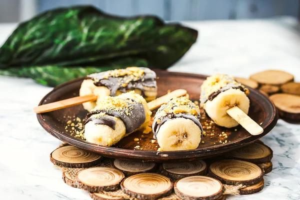 Frozen bananas with chocolate and nuts, raw summer dessert