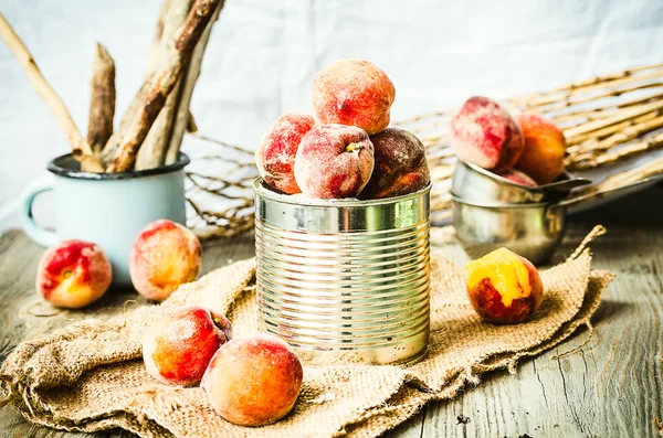 Свежие персики в жестянке, осенний деревенский фон — стоковое фото
