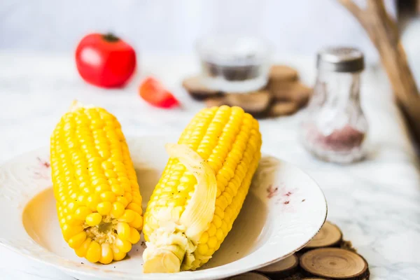 Boiled sweet corn and tomatoes with salt and black, dinner — Stock Photo, Image
