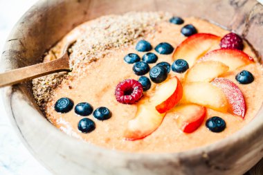 ahşap di şeftali, erik ve yaban mersini ile smoothie kase