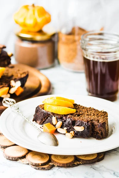 Piece of chocolate cake with pumpkin, nuts and fresh peaches, se — Stock Photo, Image