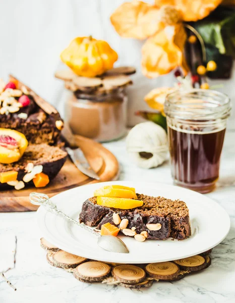 Piece of chocolate cake with pumpkin, nuts and fresh peaches, se — Stock Photo, Image