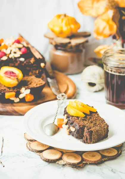 Piece of chocolate cake with pumpkin, nuts and fresh peaches, se — Stock Photo, Image