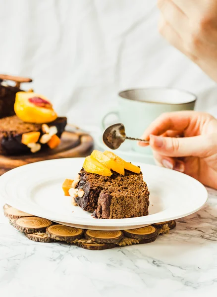 Piece of chocolate cake with pumpkin, nuts and fresh peaches on — Stock Photo, Image