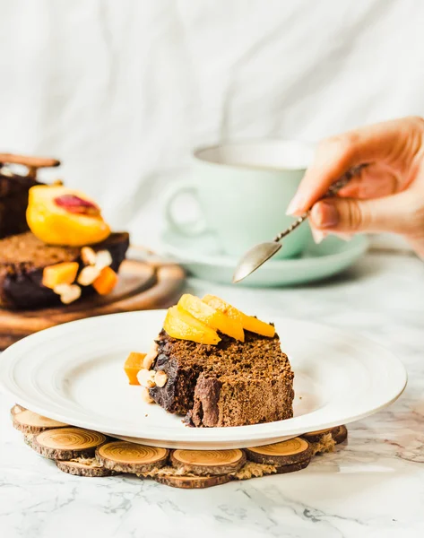 Piece of chocolate cake with pumpkin, nuts and fresh peaches — Stock Photo, Image