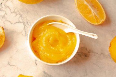 Ev yapımı taze puding ya da arka planda beyaz bir kâse içinde keskin limon püresi..